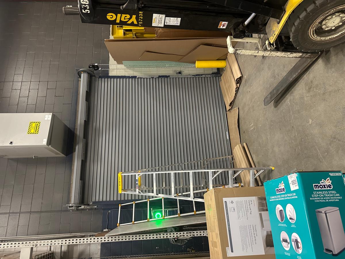 Gray commercial rolling steel door at industrial loading bay — MA